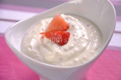 Un couple coupe un gâteau de mariage entouré de desserts décorés et de cierges magiques allumés.