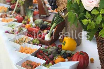 Boule croustillante sur lit de salade, garnie d'une framboise et décorée de sauce rouge sur assiette blanche.