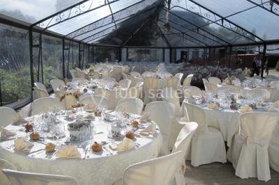 Boule croustillante sur lit de salade, garnie d'une framboise et décorée de sauce rouge sur assiette blanche.