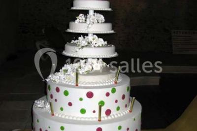 Boule croustillante sur lit de salade, garnie d'une framboise et décorée de sauce rouge sur assiette blanche.