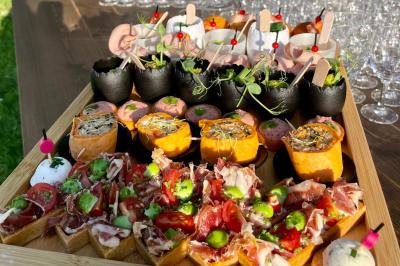 Boule croustillante sur lit de salade, garnie d'une framboise et décorée de sauce rouge sur assiette blanche.