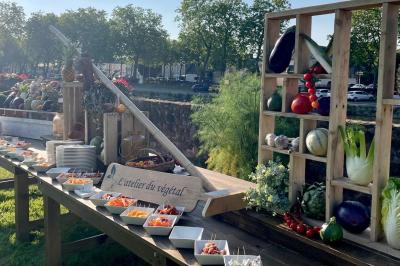 Boule croustillante sur lit de salade, garnie d'une framboise et décorée de sauce rouge sur assiette blanche.