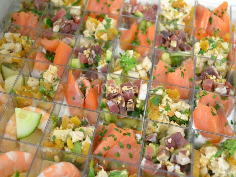 Assortiment de verrines colorées contenant du saumon, du thon, des légumes et des herbes fraîches.