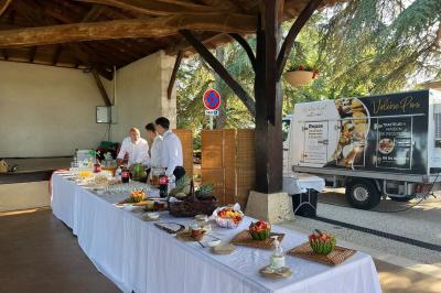 Miniature Traiteur Montauban (Tarn-et-Garonne) - Valérie Pons Traiteur #6 Décoration d'une tente événementielle avec tables ornées, barils en bois, fleurs et ballons dans un espace extérieur.