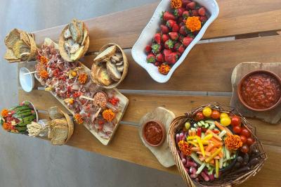 Miniature Traiteur Montauban (Tarn-et-Garonne) - Valérie Pons Traiteur #29 Décoration d'une tente événementielle avec tables ornées, barils en bois, fleurs et ballons dans un espace extérieur.