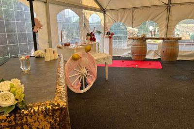 Miniature Traiteur Montauban (Tarn-et-Garonne) - Valérie Pons Traiteur #35 Décoration d'une tente événementielle avec tables ornées, barils en bois, fleurs et ballons dans un espace extérieur.