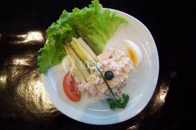 Miniature Traiteur Lezoux (Puy-de-Dôme) - Deneuville Traiteur #4 Pyramide de macarons colorés surmontée de figurines de mariés, présentée sur une table rouge en extérieur.