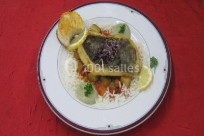 Miniature Traiteur Lezoux (Puy-de-Dôme) - Deneuville Traiteur #6 Pyramide de macarons colorés surmontée de figurines de mariés, présentée sur une table rouge en extérieur.