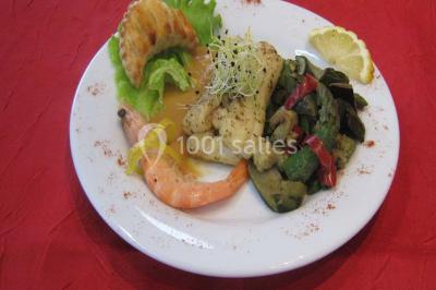 Miniature Traiteur Lezoux (Puy-de-Dôme) - Deneuville Traiteur #8 Pyramide de macarons colorés surmontée de figurines de mariés, présentée sur une table rouge en extérieur.