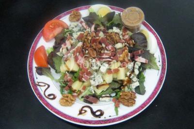 Miniature Traiteur Lezoux (Puy-de-Dôme) - Deneuville Traiteur #11 Pyramide de macarons colorés surmontée de figurines de mariés, présentée sur une table rouge en extérieur.