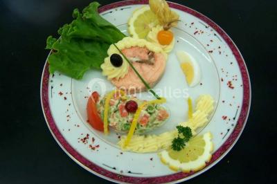 Miniature Traiteur Lezoux (Puy-de-Dôme) - Deneuville Traiteur #13 Pyramide de macarons colorés surmontée de figurines de mariés, présentée sur une table rouge en extérieur.