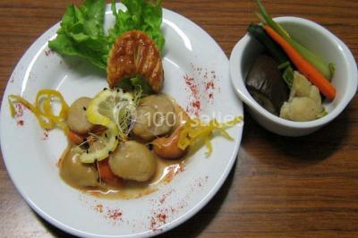 Miniature Traiteur Lezoux (Puy-de-Dôme) - Deneuville Traiteur #15 Pyramide de macarons colorés surmontée de figurines de mariés, présentée sur une table rouge en extérieur.