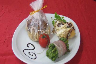 Miniature Traiteur Lezoux (Puy-de-Dôme) - Deneuville Traiteur #16 Pyramide de macarons colorés surmontée de figurines de mariés, présentée sur une table rouge en extérieur.