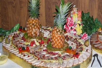 Miniature Traiteur Lezoux (Puy-de-Dôme) - Deneuville Traiteur #20 Pyramide de macarons colorés surmontée de figurines de mariés, présentée sur une table rouge en extérieur.