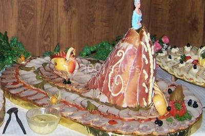 Miniature Traiteur Lezoux (Puy-de-Dôme) - Deneuville Traiteur #21 Pyramide de macarons colorés surmontée de figurines de mariés, présentée sur une table rouge en extérieur.