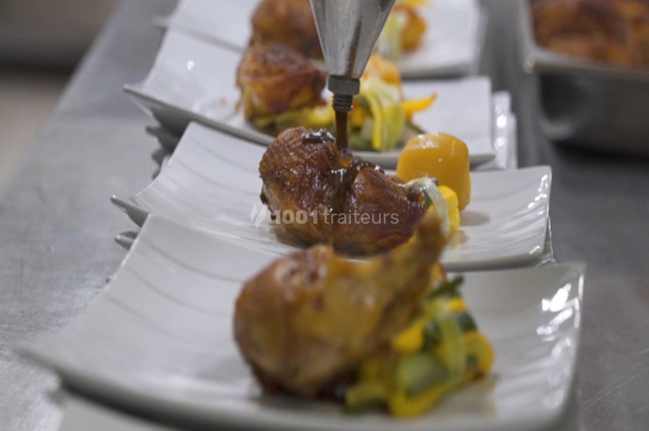 Assiette de viande rôtie avec légumes, dressée avec précision en cuisine professionnelle.