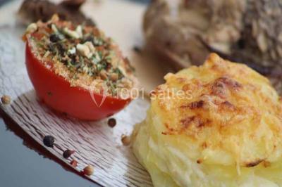 Table élégamment dressée avec bougies décoratives, serviettes pliées, verres en cristal et chemin de table sombre.