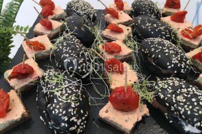 Plateau de bouchées variées comprenant mini-sandwichs, macarons, brochettes, verrines et roulés aux légumes.