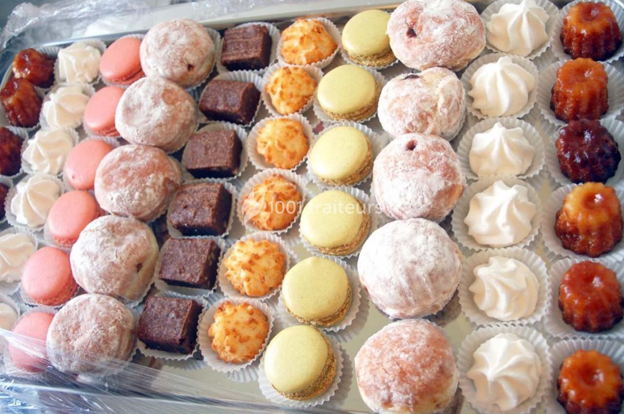 Plateau de pâtisseries variées comprenant macarons, beignets, cannelés, meringues et bouchées chocolatées.