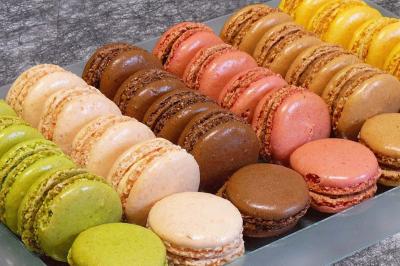 Plateau de bouchées variées comprenant mini-sandwichs, macarons, brochettes, verrines et roulés aux légumes.