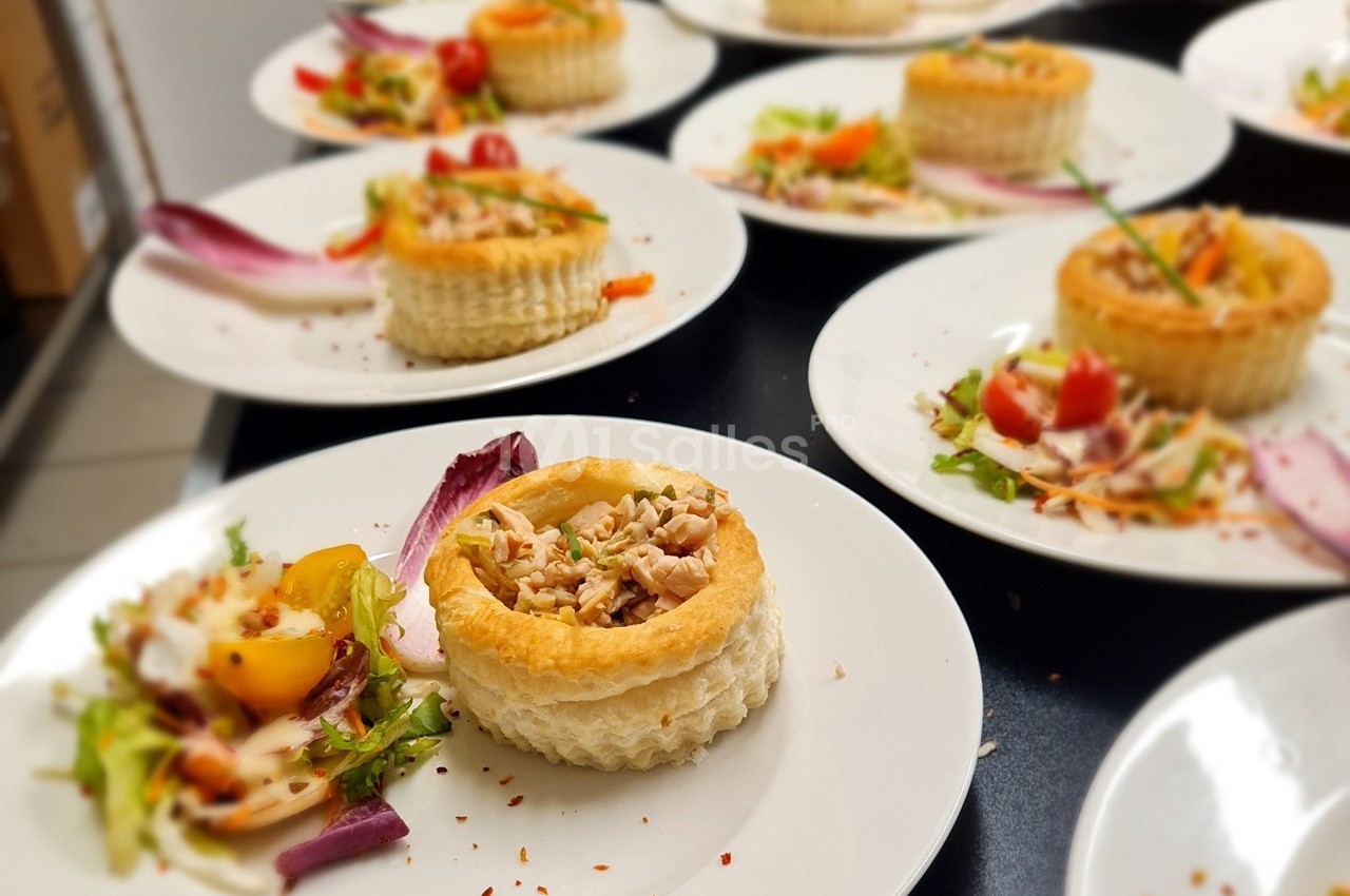 Assiette contenant un vol-au-vent garni de poulet et accompagné d'une salade colorée avec des légumes frais.