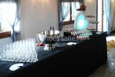 Miniature Traiteur Unverre (Eure-et-Loir) - Spirale Gourmande #7 Table de buffet dressée en extérieur avec boissons, verrines, desserts et une pièce montée sur une nappe noire.