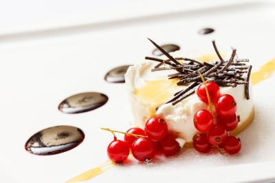 Un serveur portant un plateau avec des flûtes de champagne lors d'un événement en extérieur sous des arbres.