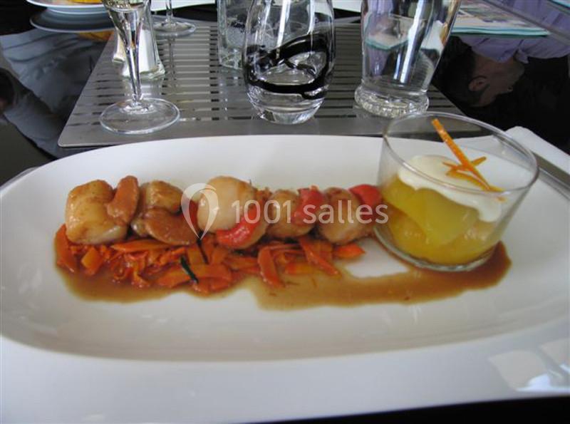 Assiette composée de noix de Saint-Jacques sur lit de carottes et d'un dessert en verrine avec fruits et crème.