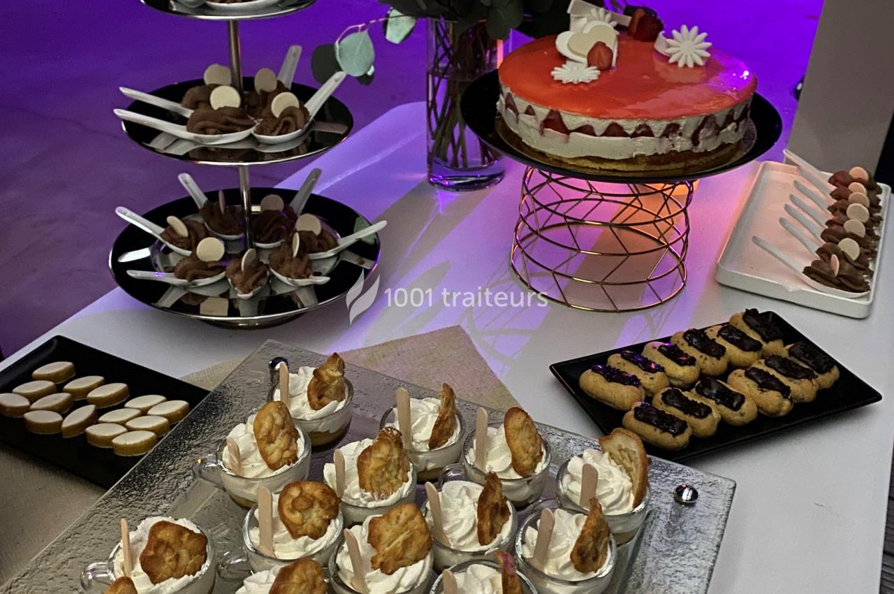 Desserts variés présentés sur une table, incluant gâteaux, verrines de crème et biscuits décorés.