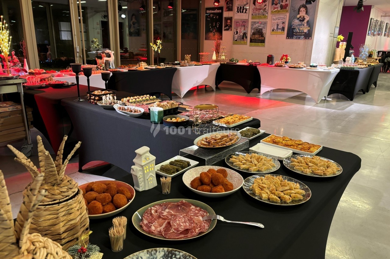 Buffet varié avec des plats salés et sucrés disposés sur des tables dans une salle éclairée.
