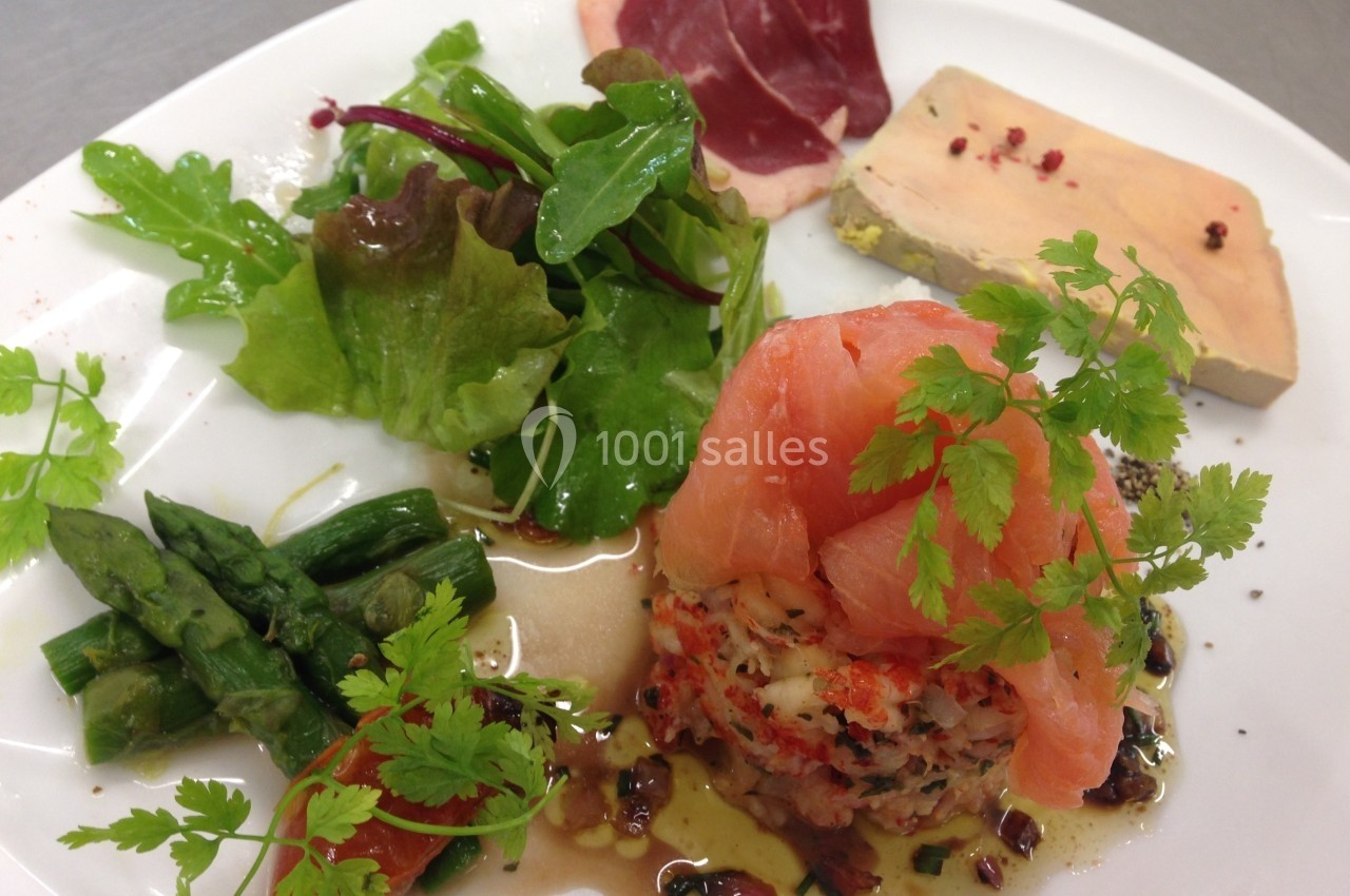 Assiette composée de saumon fumé, tartare, foie gras, salade verte, asperges et viande séchée.