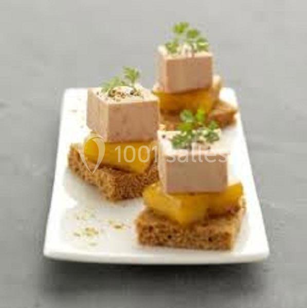 Bouchées de foie gras sur pain d'épices avec morceaux de mangue et garniture d'herbes fraîches, servies sur une assiette…