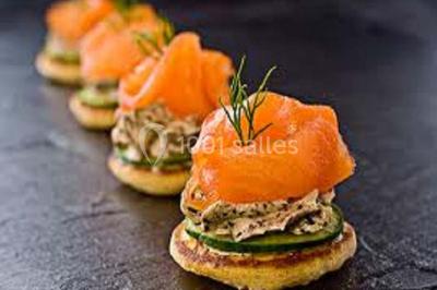 Blinis garnis de tranches de saumon fumé, crème aux herbes, rondelles de concombre et brins d'aneth.
