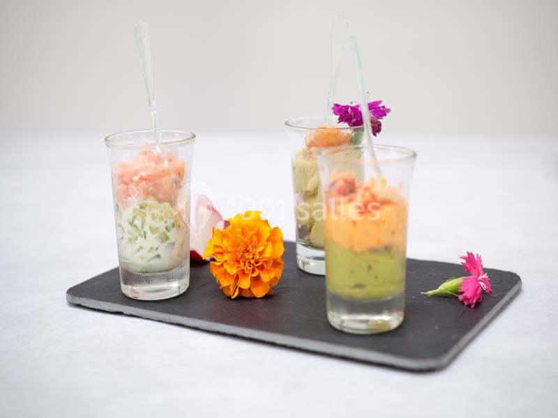 Traiteur Arsac (Gironde) - Domaine de Cordet #5 Trois verrines colorées garnies de préparations variées, présentées sur une ardoise avec des fleurs décoratives.