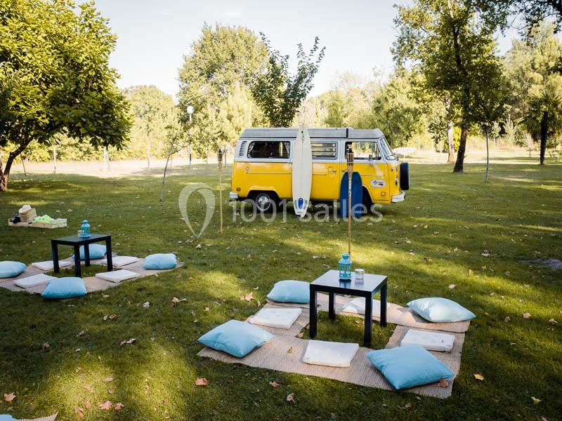 Traiteur Arsac (Gironde) - Domaine de Cordet #26 Un van jaune stationné dans un parc verdoyant, entouré de coussins et de tables basses pour un pique-nique.