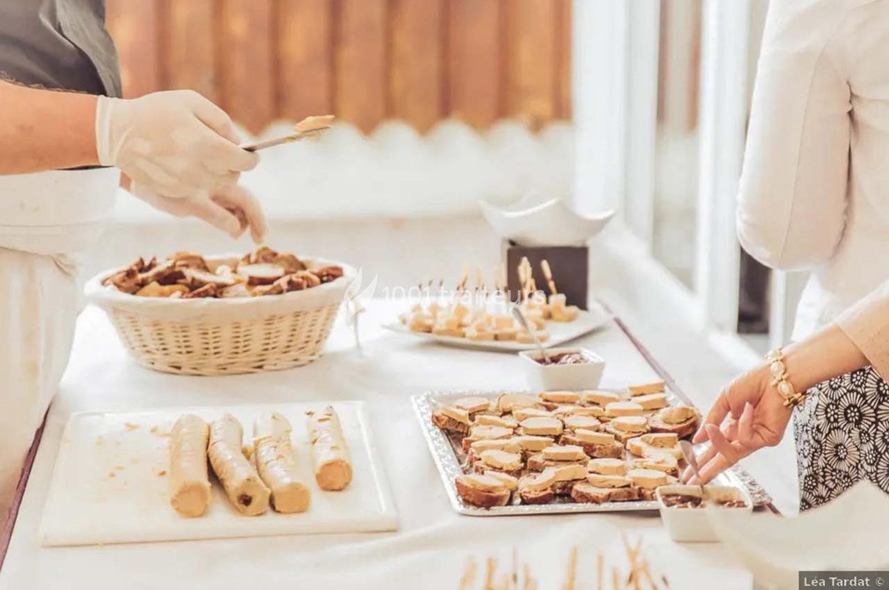 Traiteur Arsac (Gironde) - Domaine de Cordet #11 Personnes préparant et disposant des amuse-bouches sur une table garnie de plateaux et d'un panier de pain.