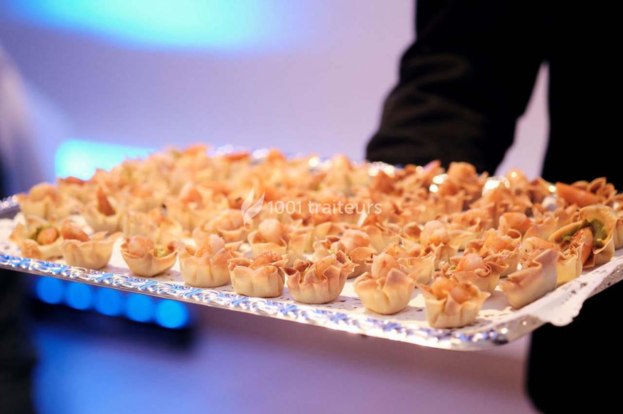 Traiteur Arsac (Gironde) - Domaine de Cordet #15 Plateau de bouchées apéritives garnies de charcuterie, présenté par une personne en tenue sombre.