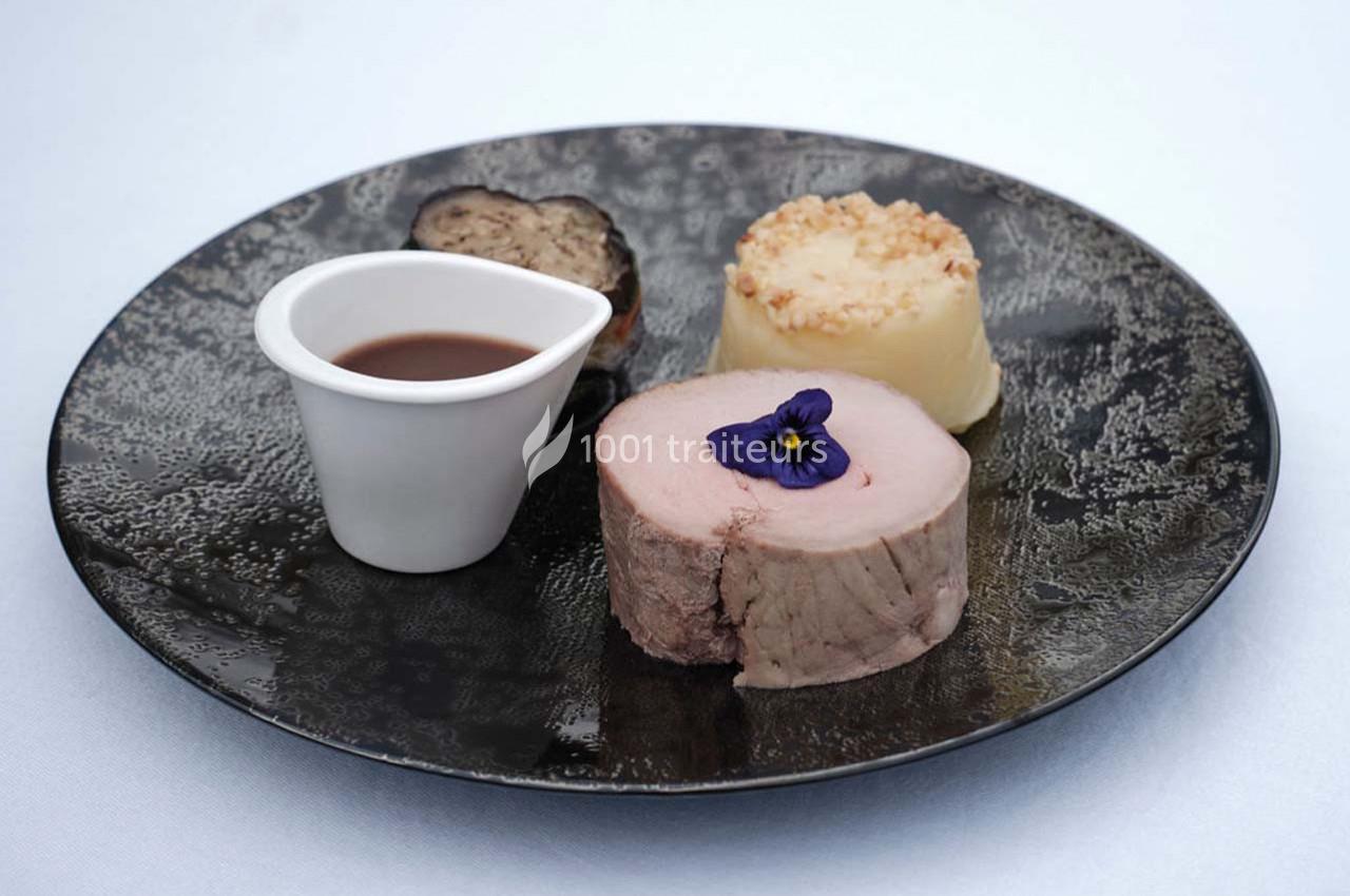 Traiteur Arsac (Gironde) - Domaine de Cordet #20 Assiette gastronomique avec viande, purée, truffe, sauce en récipient et fleur comestible en décoration.