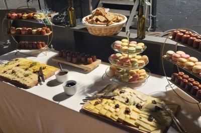 Un kiosque blanc au bord d'un étang avec une fontaine, entouré d'arbres et d'une réception en arrière-plan.