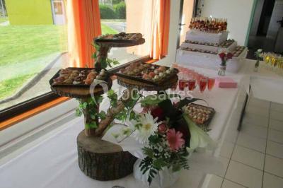 Plateau de canapés variés comprenant des bouchées salées et sucrées, disposées sur une table en inox.