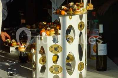 Plateau de canapés variés comprenant des bouchées salées et sucrées, disposées sur une table en inox.