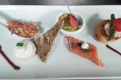 Plateau de canapés variés comprenant des bouchées salées et sucrées, disposées sur une table en inox.