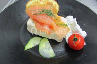 Plateau de canapés variés comprenant des bouchées salées et sucrées, disposées sur une table en inox.