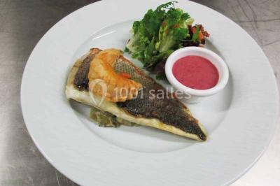 Plateau de canapés variés comprenant des bouchées salées et sucrées, disposées sur une table en inox.