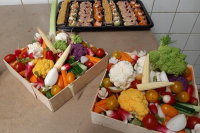 Plateau de canapés variés comprenant des bouchées salées et sucrées, disposées sur une table en inox.