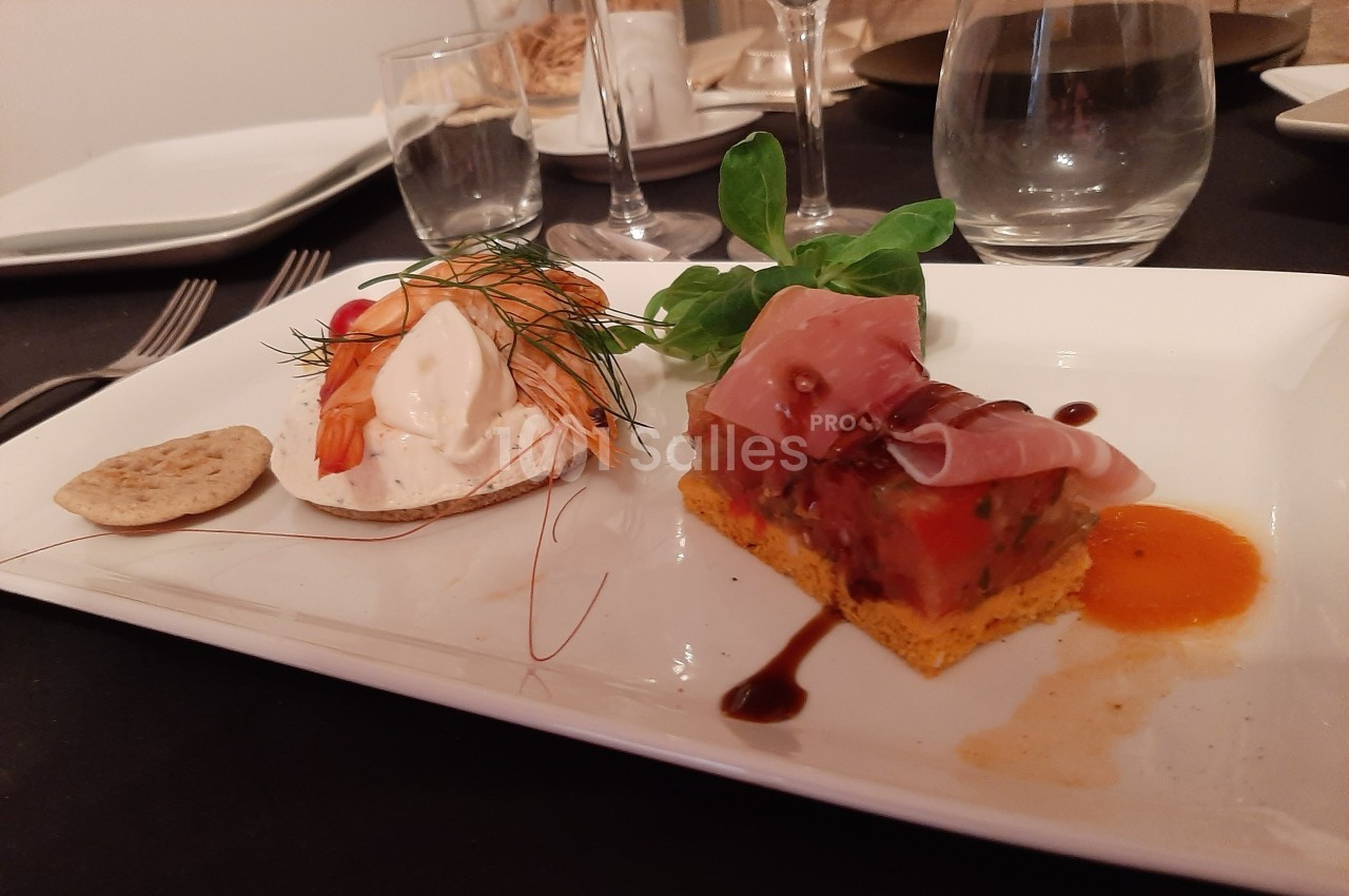 Assiette gastronomique avec tartine de crevettes et fromage frais, et millefeuille de légumes au jambon cru.