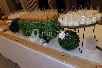 Miniature Traiteur Limas (Rhône) - Marc et Sophie Traiteur Cuisine & Services #3 Tour de choux décorée avec des fleurs et des étincelles, entourée de desserts sur une table de réception.