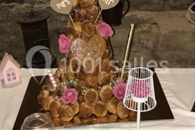 Miniature Traiteur Limas (Rhône) - Marc et Sophie Traiteur Cuisine & Services #18 Tour de choux décorée avec des fleurs et des étincelles, entourée de desserts sur une table de réception.