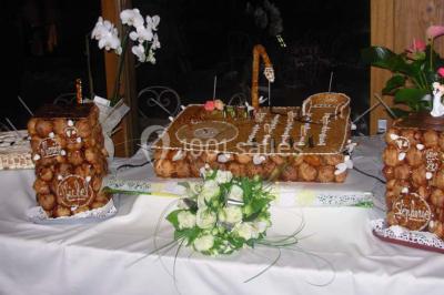 Miniature Traiteur Limas (Rhône) - Marc et Sophie Traiteur Cuisine & Services #20 Tour de choux décorée avec des fleurs et des étincelles, entourée de desserts sur une table de réception.