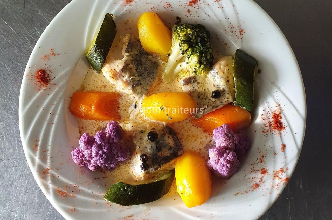 Assiette de légumes colorés (courgettes, carottes, brocolis, chou-fleur violet) et sauce crémeuse, servie avec des épices.